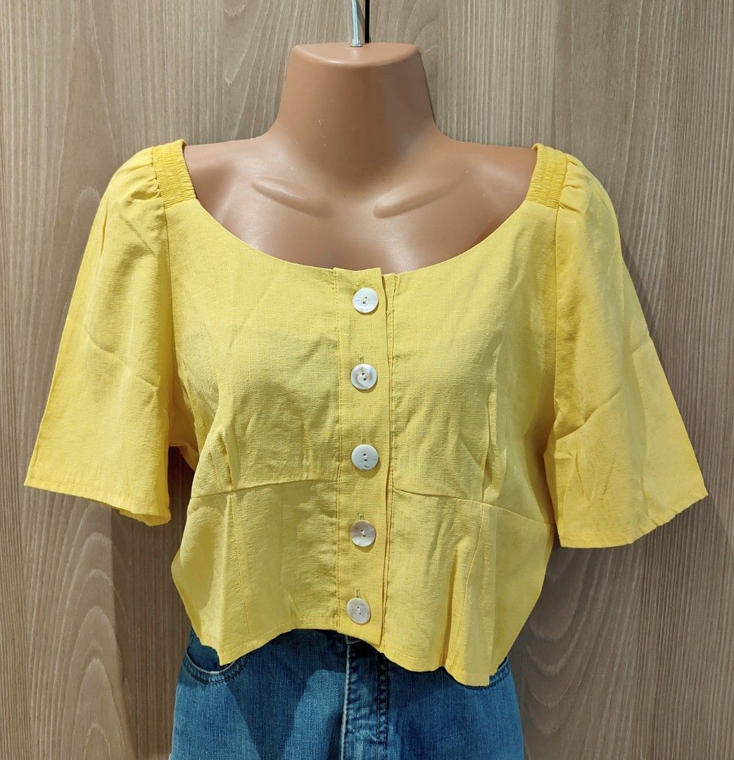 Yellow Square Neck Button-Down Crop Top (Category: Blouses) located in Pasig City. Submitted by iammkds (Listing ID 1469726698, Image 1). Description: Size: Fits Small to Medium (S–M) ***For reference: I am 5'3" tall and weigh 50 kg. Condition: Good condition. No damage or issues. Worn only 3 or 4 times. Great fit for larger bust sizes. Style: Linen. Square-neck button-front cropped blouse with flared short sleeves and back smocking detail. MOP: 