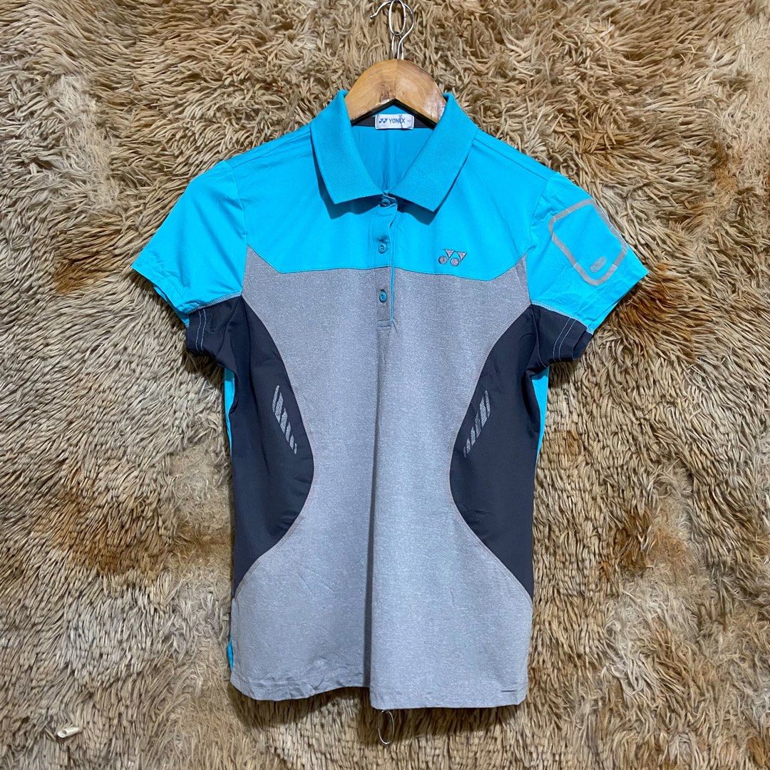 Yonex Blue Grey Athletic Polo Shirt (Category: Activewear) located in Butuan. Submitted by jc13thrifts (Listing ID 1469752504, Image 1). Description: - Brand: Yonex - Colorway: Blue, grey, and dark charcoal - Size: 90 (Inner collar tag) - Design: Short sleeves with silver graphic outline, classic collar, and 3-button placket with branded buttons - Detailing: Embroidered Yonex logo on the chest - Material: Lightweight fabric - Ideal for: Badminton