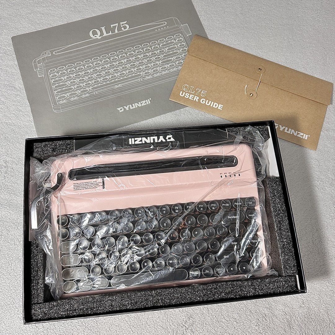 YUNZII QL75 Typewriter Keyboard in Pink (Category: Computer Keyboard) located in Paranaque City. Submitted by hershey_august (Listing ID 1469679708, Image 2). Description: - Model: YUNZII QL75 Mechanical Keyboard - Color: Pink - Design: Vintage typewriter style with circular keycaps and a functional metal pull bar - Layout: Compact 75 percent - Connectivity: Wireless with multi-device Bluetooth indicators - Inclusions: Original box, user manual, 