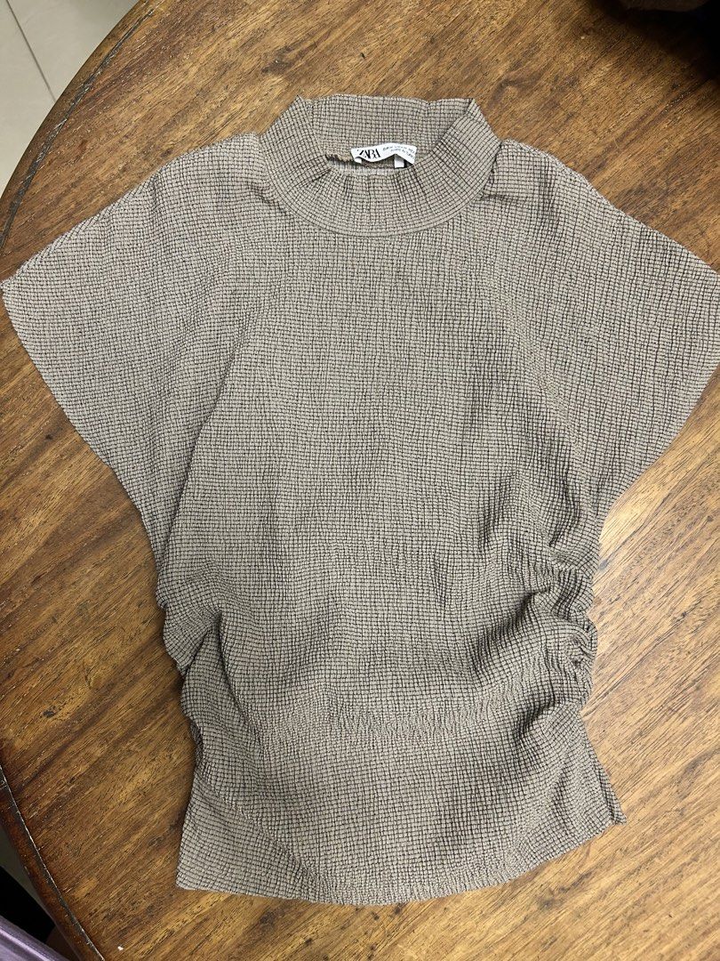 Zara Top (Category: Blouses) located in Antipolo. Submitted by tshopph (Listing ID 1469712245, Image 1). Description: Chic and stylish textured high-neck top. Features a unique crinkled/plissé grid texture, side ruched detailing for a flattering silhouette, and extended cap sleeves. Super comfortable and versatile—easy to dress up with tailored trousers or dress down with high-waisted jeans Condition: like new Size: medium Price: ₱350 Same-day de