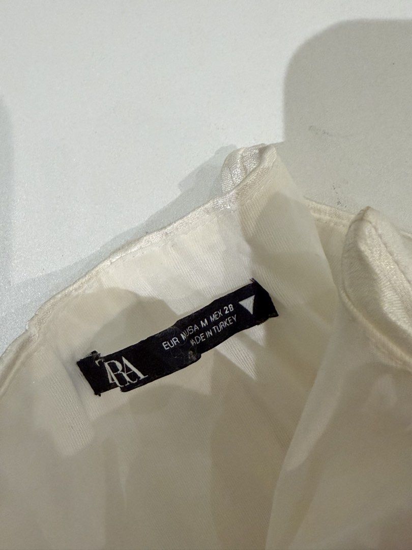Zara White Corset Top Size M (Category: Sleeveless) located in Muntinlupa City. Submitted by henlo03 (Listing ID 1469613523, Image 2). Description: - Brand/Model: Zara White Corset Top - Size: M (Made in Turkey) - Design: Sweetheart neckline, subtle front ruching texture, and center front hook-and-eye closure - Structure: Built-in boning throughout for shape and support - Condition: Great overall, with minor yellowing near the bottom hem (visible