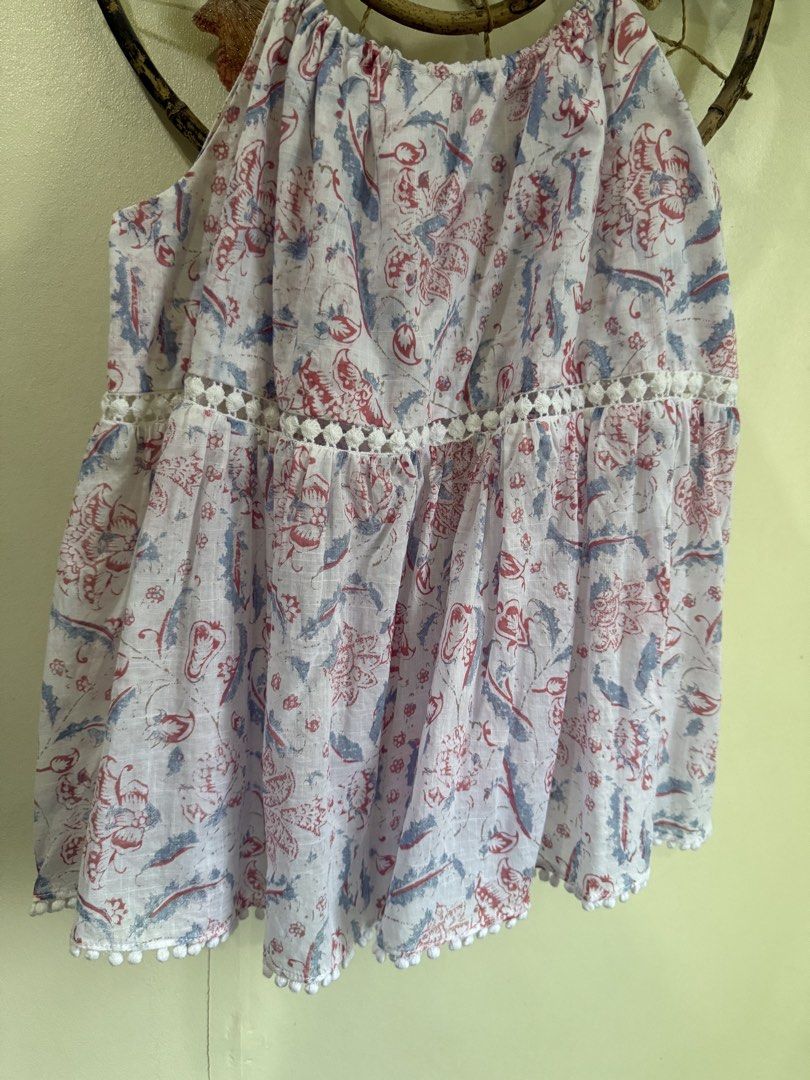 Zimmermann cotton printed tank top size 0 (Category: Sleeveless) located in Cebu City. Submitted by hotchkisscebu (Listing ID 1469643394, Image 3). Description: - Brand: Zimmermann - Material: 100% lightweight and breezy cotton - Design: White base with a vibrant red and blue floral print - Details: Delicate spaghetti straps with hardware adjusters, chic cutout lace trim around the midsection, and playful pom-pom trim along the bottom hem - Size: