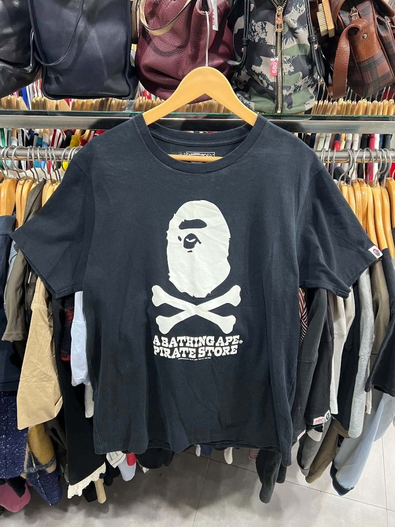 A Bathing Ape Pirate Store Black T-Shirt (Category: Tshirts & Polo Shirts ) located in Urdaneta. Submitted by jayceegarage (Listing ID 1469903689, Image 1). Description: - Brand: A Bathing Ape (BAPE) Pirate Store - Color: Black - Size: Medium - Design: Large white ape head and crossbones chest graphic - Material: 100% cotton (Made in China) - Condition: Clean piece with neck tag and care labels intact - Style: Classic crewneck, short sleeves stre