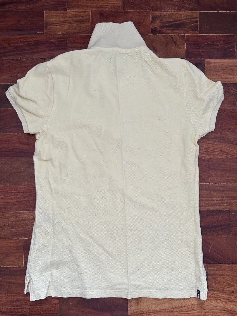 Able Jeans Yellow Graphic Polo Shirt Medium (Category: Tshirts & Polo Shirts ) located in Cainta. Submitted by buy.preloved (Listing ID 1469791122, Image 3). Description: - Brand: Able Jeans - Color: Light yellow - Size: Medium (tag inside collar) - Design: Embroidered 'ABLE JEANS MAKE IT HAPPEN' with detailed bird and feather graphics trailing to the hem - Style: Classic collar, 3-button placket, short sleeves - Condition: Excellent pre-loved co