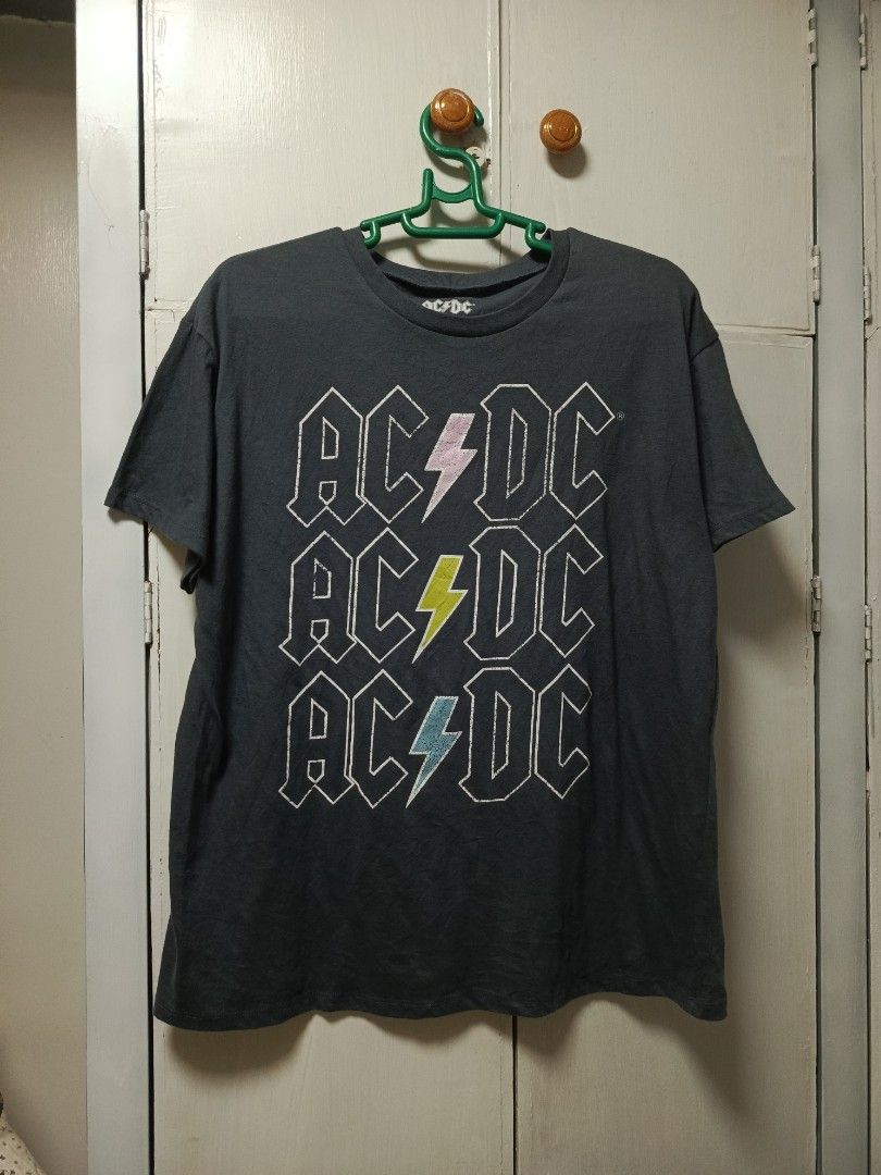 AC/DC Graphic Tee Dark Grey XL (Category: Tshirts & Polo Shirts ) located in Cabatuan. Submitted by penthegreat (Listing ID 1469781688, Image 1). Description: 21 or 22 width & 26 length - Band: Official AC/DC merchandise (2023) - Color: Dark grey with a plain back - Design: Stacked logo with colorful lightning bolts on the front - Size: XL (tag printed inside the collar) - Material: 50% cotton, 50% polyester blend - Origin: Made in Guatemala.