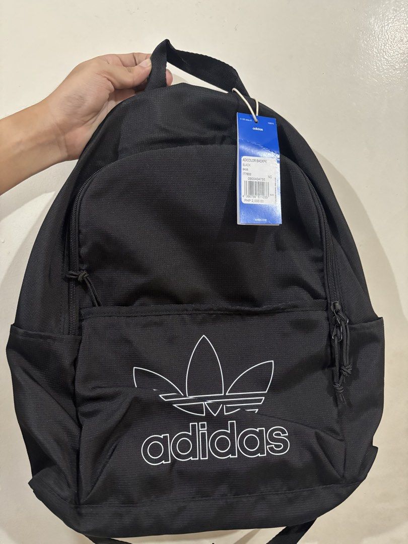 Adidas Adicolor Backpack Black (Category: Backpacks) located in Manila. Submitted by karinaaaaaaa2000 (Listing ID 1469777529, Image 1). Description: - Brand: Adidas - Model: Adicolor Backpack (Style: IT7602) - Color: Black with large white trefoil logo - Condition: Brand new with original store tags - Retail Price: PHP 2,000.00 - Features: Zip closure, top carry handle, adjustable mesh shoulder straps, and interior slip pocket with Adidas logo pa