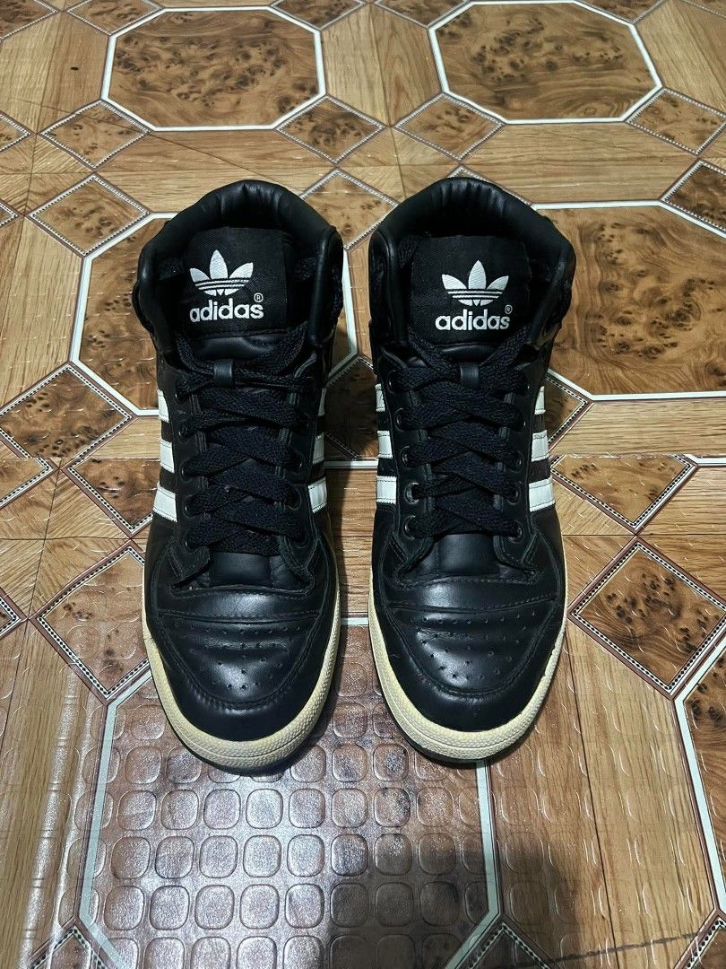 Adidas Black High Top Sneakers (Category: Sneakers) located in Cagayan de Oro. Submitted by friderickv99131 (Listing ID 1469921293, Image 3). Description: Black high top sneakers from Adidas with classic white three stripes. Large trefoil logo printed on the side collar. Yellowed midsoles give them a vintage look. Black laces and perforated toe box. Solid black rubber outsoles. Great streetwear style. Wear on casual days..