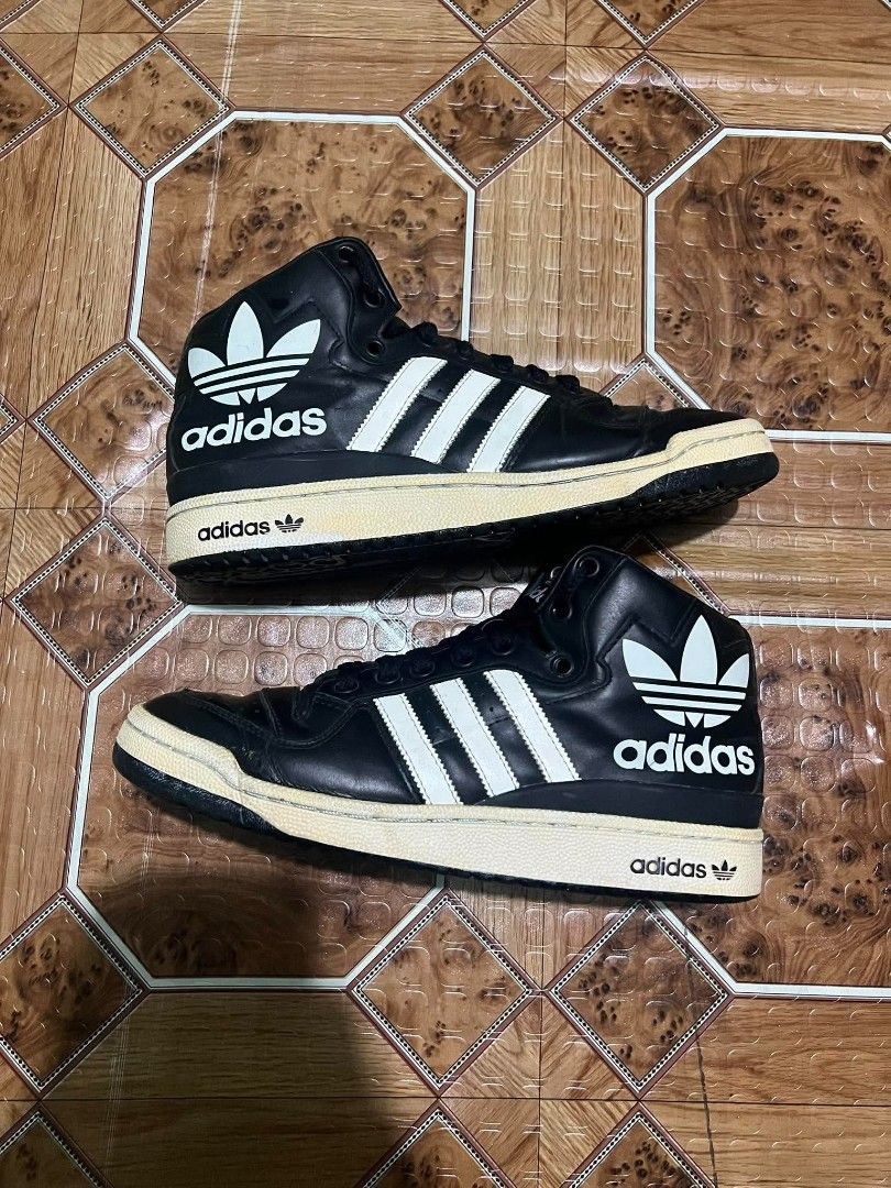 Adidas Black High Top Sneakers (Category: Sneakers) located in Cagayan de Oro. Submitted by friderickv99131 (Listing ID 1469921293, Image 1). Description: Black high top sneakers from Adidas with classic white three stripes. Large trefoil logo printed on the side collar. Yellowed midsoles give them a vintage look. Black laces and perforated toe box. Solid black rubber outsoles. Great streetwear style. Wear on casual days..