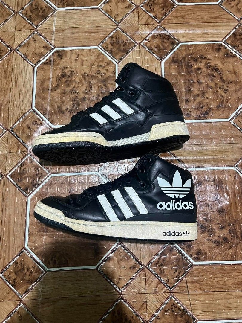 Adidas Black High Top Sneakers (Category: Sneakers) located in Cagayan de Oro. Submitted by friderickv99131 (Listing ID 1469921293, Image 2). Description: Black high top sneakers from Adidas with classic white three stripes. Large trefoil logo printed on the side collar. Yellowed midsoles give them a vintage look. Black laces and perforated toe box. Solid black rubber outsoles. Great streetwear style. Wear on casual days..