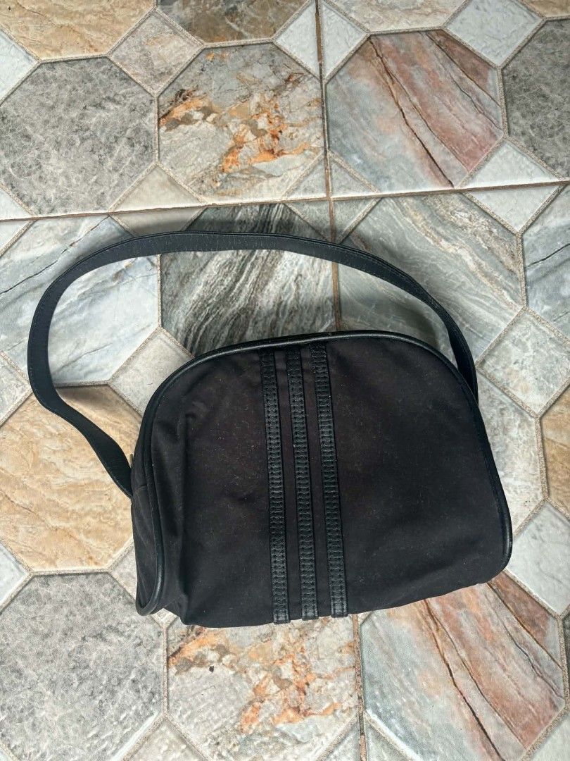 Adidas Black Shoulder Bag (Category: Sling Bags) located in Caloocan City. Submitted by joshuadyogi0122 (Listing ID 1469810791, Image 2). Description: - Brand: Adidas - Color: Classic black with light grey interior lining - Design: Iconic three stripes on front with metal Adidas logo plate - Closure: Secure zip closure with branded metal puller - Compartments: Handy inner slip pocket for organization - Details: Production date 05/06, Article No. 