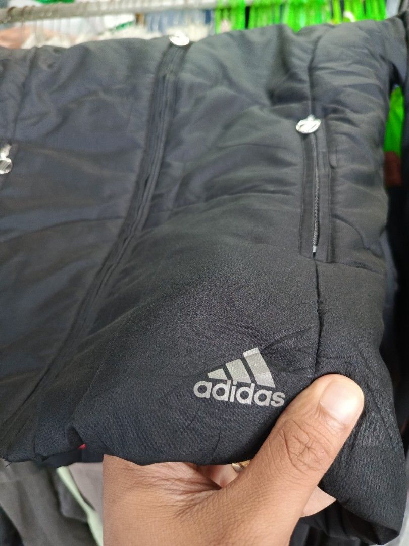 Adidas Black Winter Puffer Jacket Size S (Category: Coats, Jackets and Outerwear) located in Cabatuan. Submitted by penthegreat (Listing ID 1469888146, Image 2). Description: - Brand: Adidas - Style: Puffer jacket with full zip front and stand-up collar - Color: Black exterior with a vibrant bright red inner lining - Size: S (Tag: 160/84A) - Pockets: Secure zippered pockets on both sides - Details: Subtle Adidas logo near the bottom hem and debos