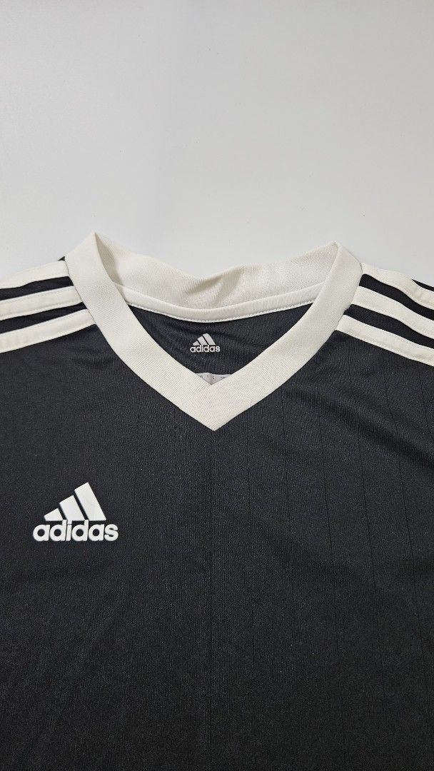 Adidas Climalite Black T-shirt (Category: Shirts) located in Alfonso. Submitted by jbcamet (Listing ID 1469861866, Image 2). Description: - Authentic Adidas youth sports t-shirt in black - Size 140 (Youth sizing) - Climalite fabric technology wicks away sweat to keep you dry during training - Features contrasting white v-neck collar and signature shoulder stripes - Small printed Adidas logo on the chest - Made in Cambodia - Perfect for school spo