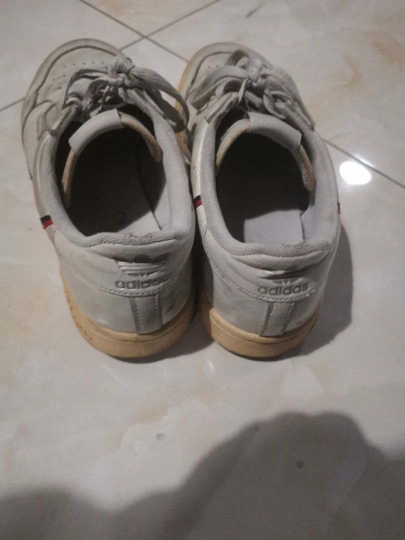 Adidas Continental 80 White Sneakers (Category: Sneakers) located in Manila. Submitted by hb1118 (Listing ID 1469892984, Image 3). Description: White leather Adidas Continental 80 sneakers with red and navy side stripes. Lace-up closure with trefoil logo on tongue and side window. Noticeable wear on white leather uppers, creasing near toes, and scuffing on midsoles. Inner heel lining damaged on the left shoe. Soles show dirt and wear patterns und