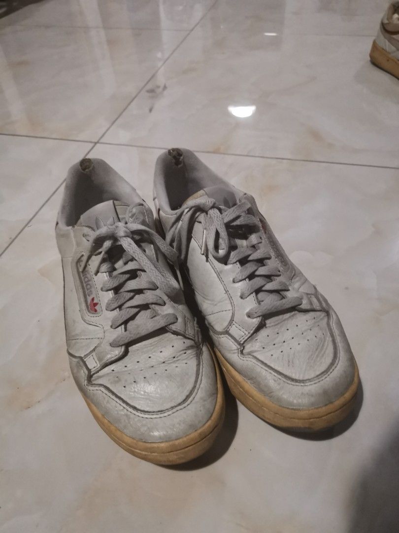 Adidas Continental 80 White Sneakers (Category: Sneakers) located in Manila. Submitted by hb1118 (Listing ID 1469892984, Image 1). Description: White leather Adidas Continental 80 sneakers with red and navy side stripes. Lace-up closure with trefoil logo on tongue and side window. Noticeable wear on white leather uppers, creasing near toes, and scuffing on midsoles. Inner heel lining damaged on the left shoe. Soles show dirt and wear patterns und