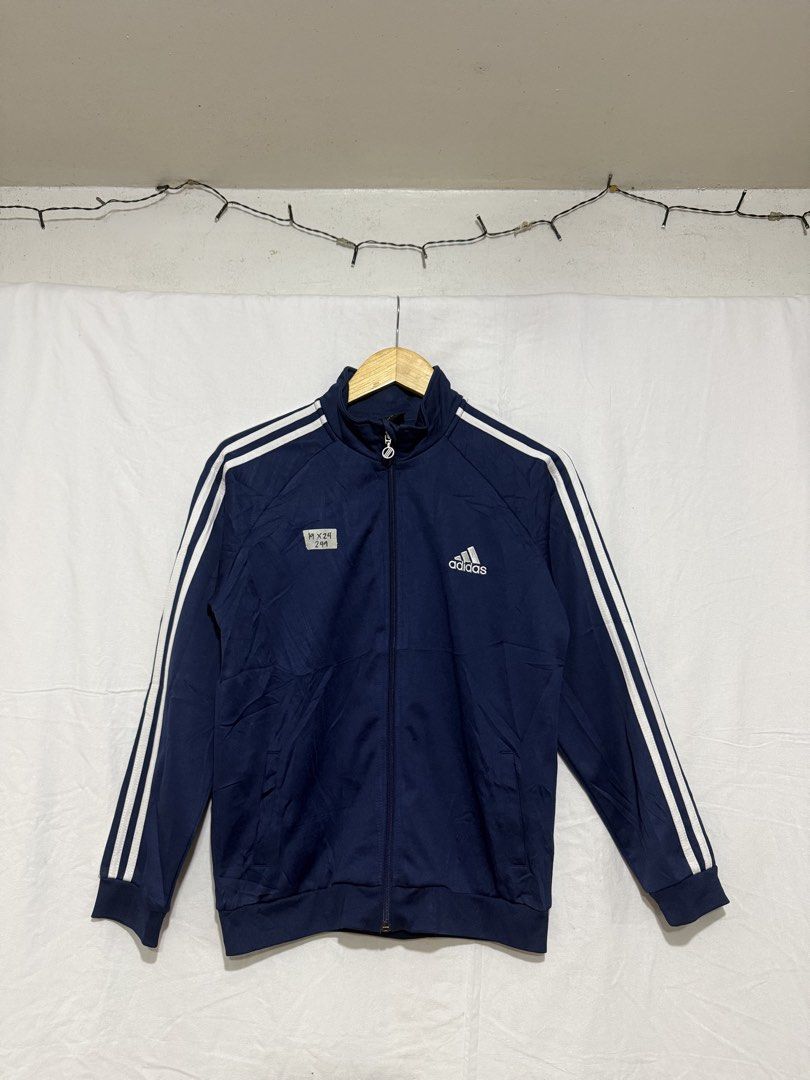Adidas Navy Blue Track Jacket With White Stripes (Category: Coats, Jackets and Outerwear) located in Quezon City. Submitted by dapanaaaay (Listing ID 1469926148, Image 1). Description: - Authentic Adidas track jacket in classic navy blue - Iconic white three stripes on sleeves and white logo on chest - Full zip closure with comfy ribbed cuffs and hem - Measurements: 19" width x 24" length - Condition: Excellent / Ready to wear - Ships fast via J&