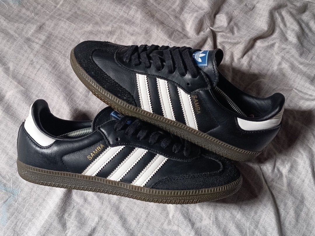 Adidas Samba Black White Sneakers (Category: Sneakers) located in Manila. Submitted by keenforest.c4b4c0 (Listing ID 1469865717, Image 1). Description: - Classic Adidas Samba sneakers in timeless black and white leather - Iconic gum soles with plenty of tread left - Premium suede toe overlays and stylish gold foil lettering - Blue tongue labels featuring the classic white trefoil logo - Clean interior and well-maintained condition - Versatile eve