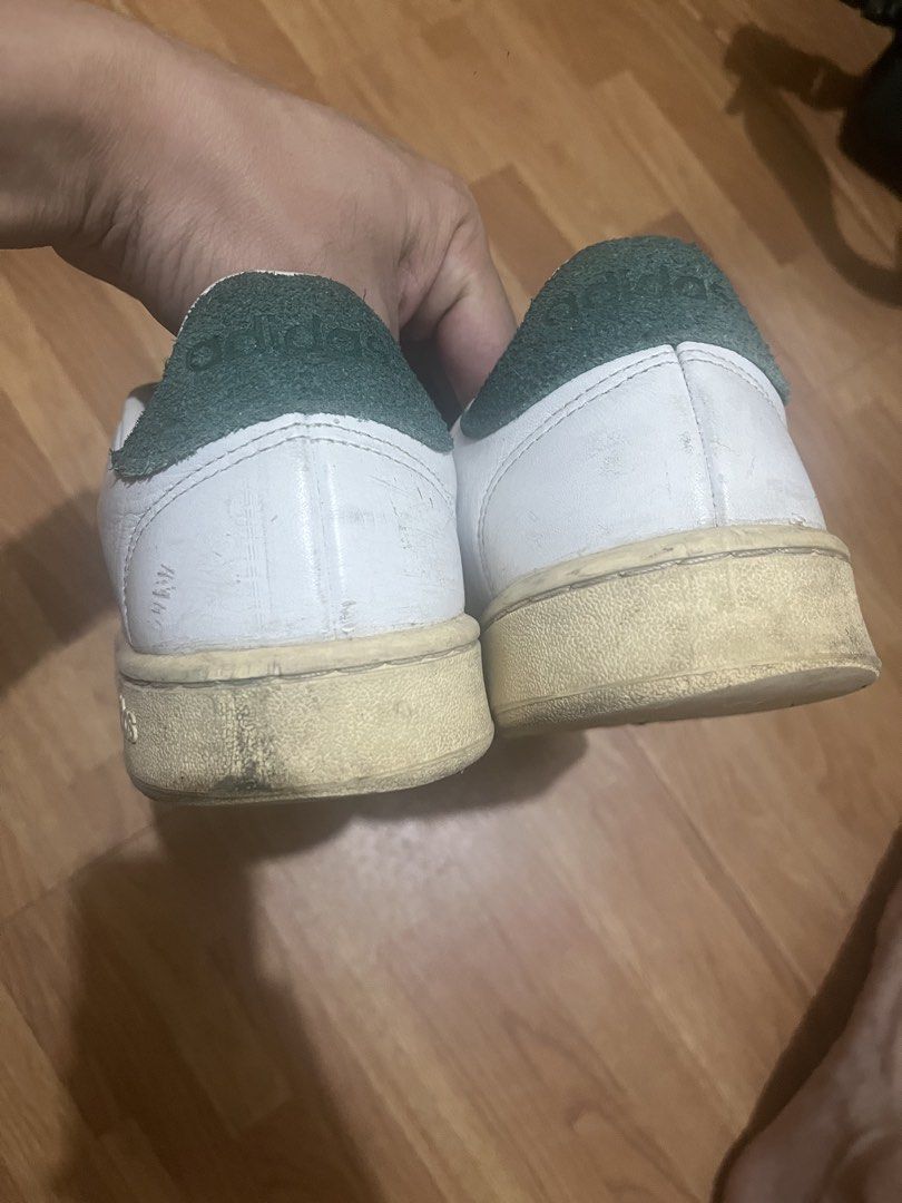 Adidas Stan Smith White Green Sneakers (Category: Casual Shoes) located in Makati City. Submitted by turonevo (Listing ID 1469827236, Image 2). Description: - Color/Material: White leather with green suede heel tabs - Details: Classic branding on the tongues, laces included - Condition: Visible yellowing on soles from age and use, scuffs on leather uppers and toe areas - Durability: Tread is still fully intact - Fit/Style: Great casual everyday p