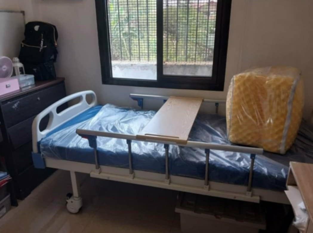 Adjustable Hospital Bed with Egg Foam and Side Rails (Category: Bed Frames & Mattresses) located in Imus. Submitted by czariri (Listing ID 1469774672, Image 3). Description: - Type: Adjustable hospital care bed with manual crank handles - Inclusions: Side safety rails, overbed table attachment, and extra yellow foam mattress cushion - Build: Sturdy metal frame with smooth-rolling wheels for easy mobility - Condition: Excellent for home patient ca