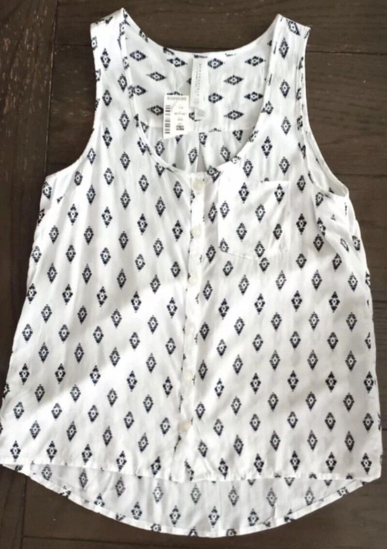 Aeropostale White Black Pattern Tank Top Size XS (Category: Sleeveless) located in Paranaque City. Submitted by calm_youngstore7 (Listing ID 1469772440, Image 1). Description: - Brand: Aeropostale - Condition: Brand new with original store tags - Size: XS - Color: White with black geometric diamond print - Features: Button-down front, chest pocket, and rounded high-low hem - Origin: Made in Indonesia.