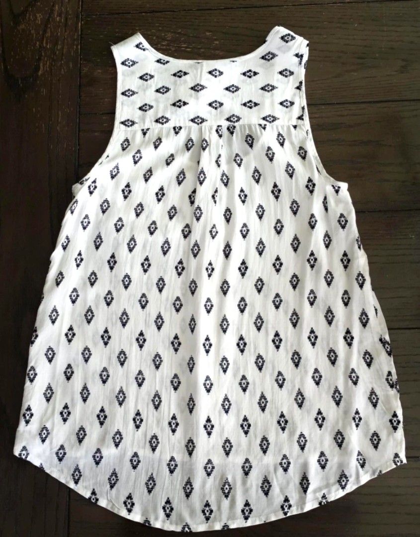 Aeropostale White Black Pattern Tank Top Size XS (Category: Sleeveless) located in Paranaque City. Submitted by calm_youngstore7 (Listing ID 1469772440, Image 2). Description: - Brand: Aeropostale - Condition: Brand new with original store tags - Size: XS - Color: White with black geometric diamond print - Features: Button-down front, chest pocket, and rounded high-low hem - Origin: Made in Indonesia.