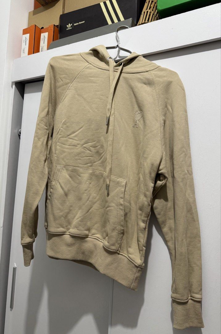 Ami Paris Beige Hooded Sweatshirt (Category: Hoodies) located in Quezon City. Submitted by vvandko (Listing ID 1469878014, Image 1). Description: AMI Paris Hoodie 🤎 Used once for an airport fit! Measurements: • Chest: 22” (pit-to-pit) • Length: 26” • Sleeve length: 28”.