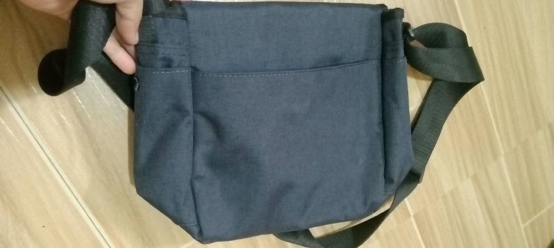 Anello dark blue messenger bag (Category: Sling Bags) located in Gapan. Submitted by montesnora80204 (Listing ID 1469785230, Image 2). Description: - Brand: Anello - Color: Dark blue - Strap: Adjustable black shoulder strap - Closure: Front flap closure with white logo print - Hardware: Includes attached Anello carabiner clip - Compartments: Main compartment with inside zip pocket, plus a back slip pocket - Condition: Clean fabric exterior and in