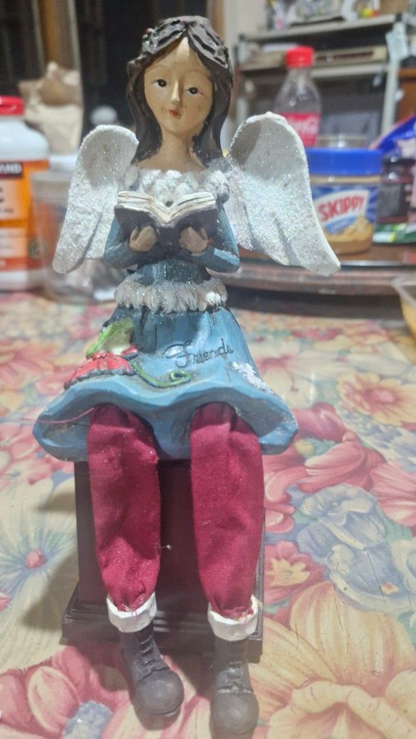 Angel figurine Only (Category: Figurines & Statues) located in Quezon City. Submitted by belikabim2014 (Listing ID 1469929380, Image 1). Description: - Angel figurine holding a small book - Blue dress with fuzzy white trim and painted red floral design - Glittery white wings on the back -8 inches long - Dangling red cloth pants with brown boots - Dark hair styled with a crown detail - display block not included.