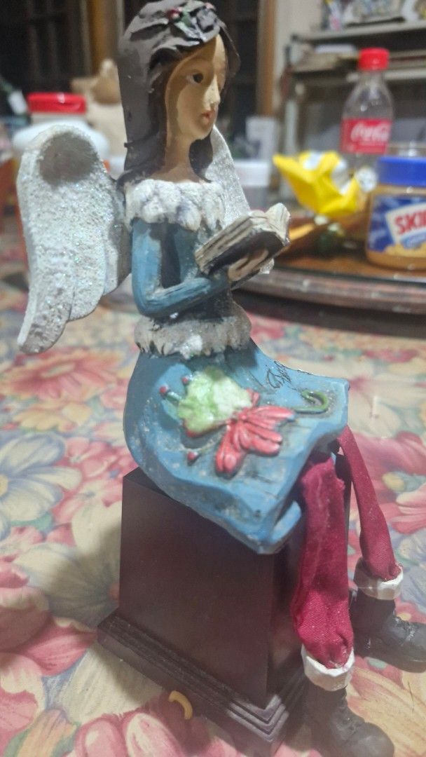 Angel figurine Only (Category: Figurines & Statues) located in Quezon City. Submitted by belikabim2014 (Listing ID 1469929380, Image 2). Description: - Angel figurine holding a small book - Blue dress with fuzzy white trim and painted red floral design - Glittery white wings on the back -8 inches long - Dangling red cloth pants with brown boots - Dark hair styled with a crown detail - display block not included.