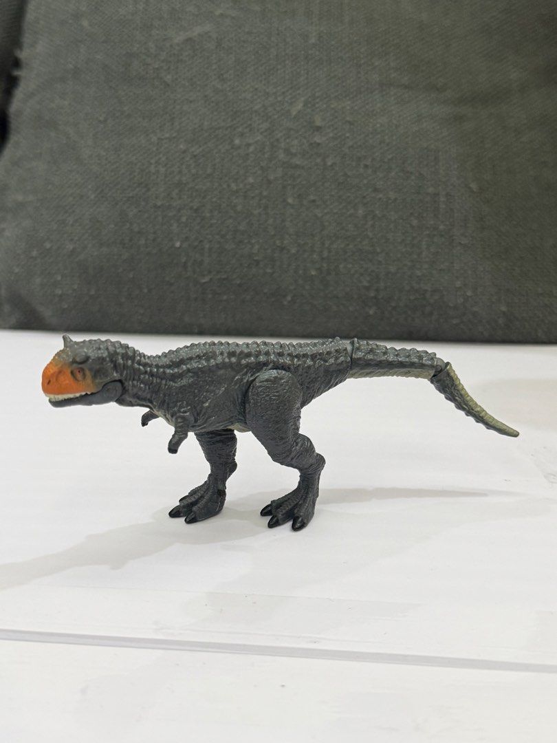 Ania Jurassic World Carnotaurus (Category: Action & Battle Toys) located in Lipa City. Submitted by cokelight11 (Listing ID 1469901287, Image 2). Description: Authentic Ania Jurassic World Carnotaurus Bring adventure to life with the Takara Tomy Ania Jurassic World Carnotaurus, featuring a striking gray body with a vivid orange and black head. Fully articulated tail, movable legs, and hinged jaw that opens wide. Stands firmly on its own for displ