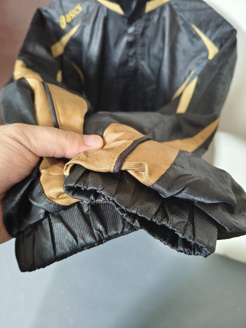 Asics Black And Gold Windbreaker Jacket (Category: Coats, Jackets and Outerwear) located in Manila. Submitted by ian.frias_ (Listing ID 1469841388, Image 3). Description: Asics windbreaker in black with gold stripe accents. Lightweight material with ribbed cuffs and full zip front. Classic sports jacket design from Asics. Great piece for runs or casual wear..