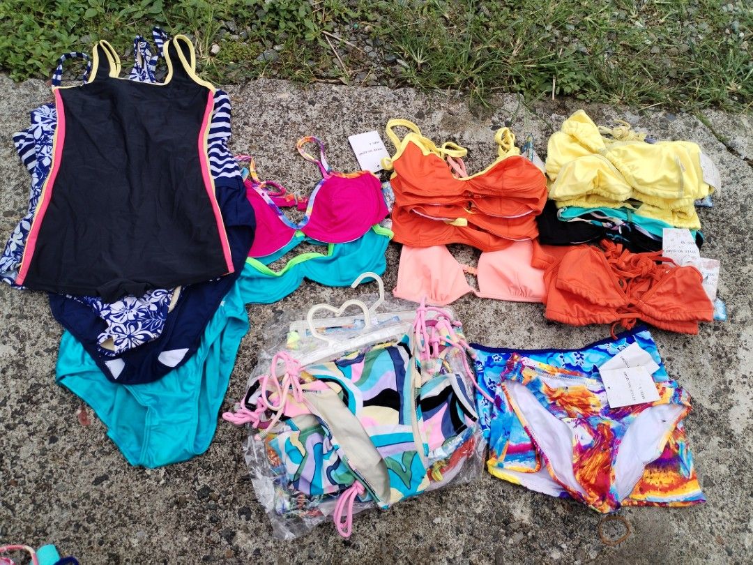 Assorted Bikinis Swimwear Lot (Category: Bikinis & Swimsuits) located in La Trinidad. Submitted by malditas (Listing ID 1469917825, Image 1). Description: - Bulk lot of women's bikinis and swimwear pieces - Assorted styles: underwire tops, triangle tops, and swim shorts - Vibrant colors and patterns including bright orange, yellow, floral prints, and abstract art designs - Several items still brand new with original store tags attached - Great mi
