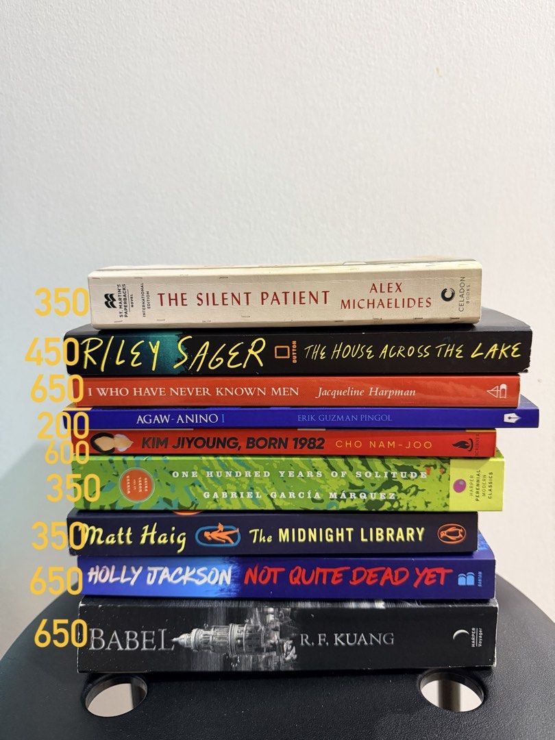 Assorted Fiction and Thriller Novels Stack (Category: Storybooks) located in Manila. Submitted by everyday_store (Listing ID 1469891859, Image 1). Description: - Set of 9 popular fiction and thriller paperbacks - Includes: The Silent Patient, The House Across The Lake, Babel, The Midnight Library, and One Hundred Years of Solitude - Authors: Alex Michaelides, Riley Sager, R.F. Kuang, Matt Haig, and Gabriel Garcia Marquez - Condition: Read once, s