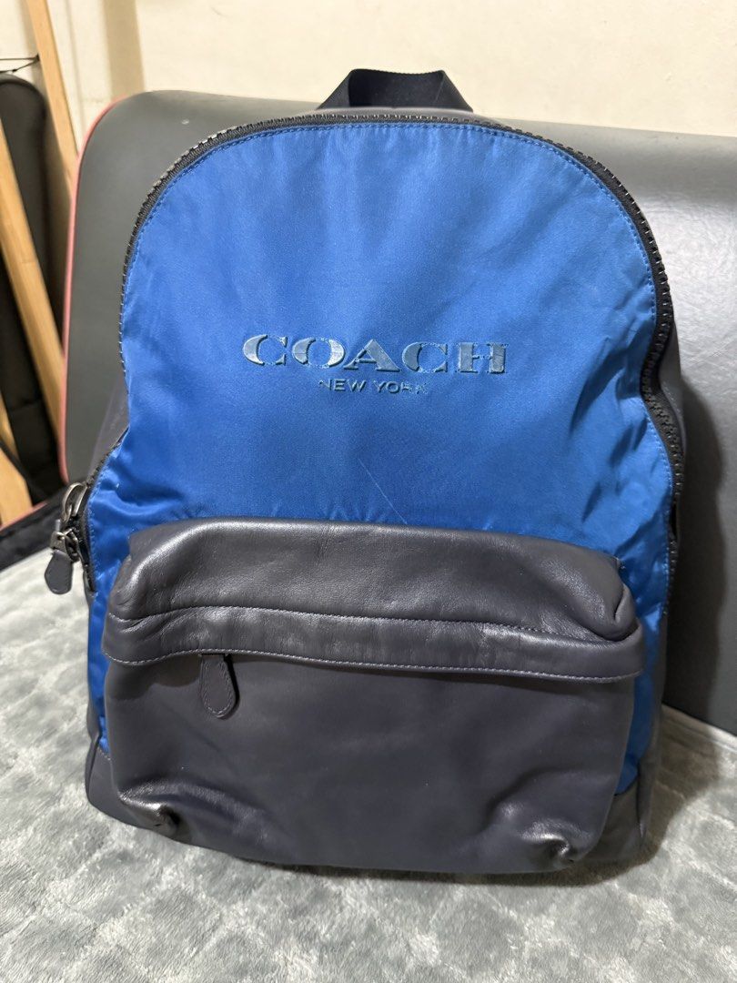 Authentic Coach New York Blue and Grey Leather Backpack (Category: Backpacks) located in Quezon City. Submitted by vianca13 (Listing ID 1469818474, Image 1). Description: - Authentic Coach New York backpack - Color: Blue nylon with dark grey leather bottom and front pocket - Large embroidered Coach logo on the front - Breathable black mesh back panel with adjustable padded straps - Black fabric interior lining with zippered pocket and leather cre