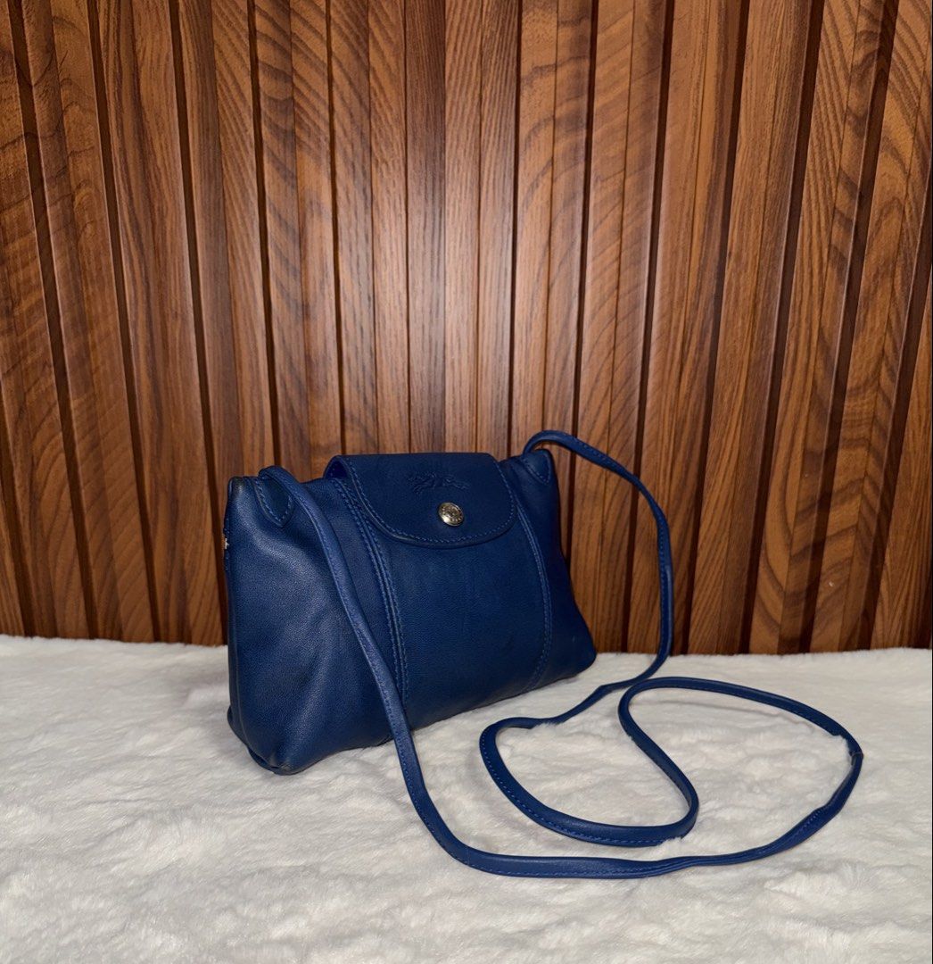 Authentic Longchamp Blue Leather Crossbody Bag (Category: Everything Else Others) located in Subic. Submitted by luxshoppe88 (Listing ID 1469861924, Image 2). Description: - Authentic Longchamp Crossbody Bag - Color: Deep Blue - Material: Premium Leather - Closure: Flap with secure snap button - Details: Back zipper pocket and thin adjustable shoulder strap - Condition: Minor scuffing on bottom corners, clean interior lining, smooth zipper - Perf