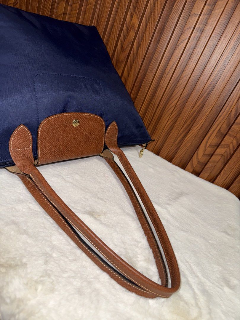 Authentic Longchamp Le Pliage Nylon Tote Bag Navy Blue (Category: Everything Else Others) located in Subic. Submitted by luxshoppe88 (Listing ID 1469863401, Image 3). Description: - Authentic Longchamp Le Pliage shoulder tote bag in classic navy blue - Brown leather handles and flap with secure gold-tone snap closure - Spacious main compartment featuring a convenient small interior pocket - Lightweight, foldable design ideal for daily commutes, w