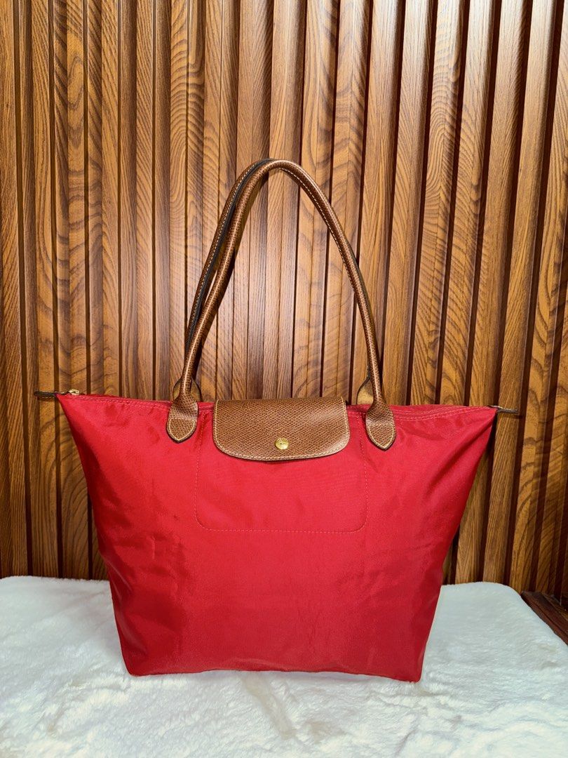 Authentic Longchamp Le Pliage Red Tote Bag (Category: Everything Else Others) located in Subic. Submitted by luxshoppe88 (Listing ID 1469864191, Image 1). Description: - Brand: Authentic Longchamp Le Pliage Red Tote Bag - Color: Vibrant red nylon with brown leather trim - Hardware: Gold-tone hardware with secure zip top and snap flap - Interior: Spacious main compartment with convenient slip pocket - Design: Lightweight, foldable, and versatile f