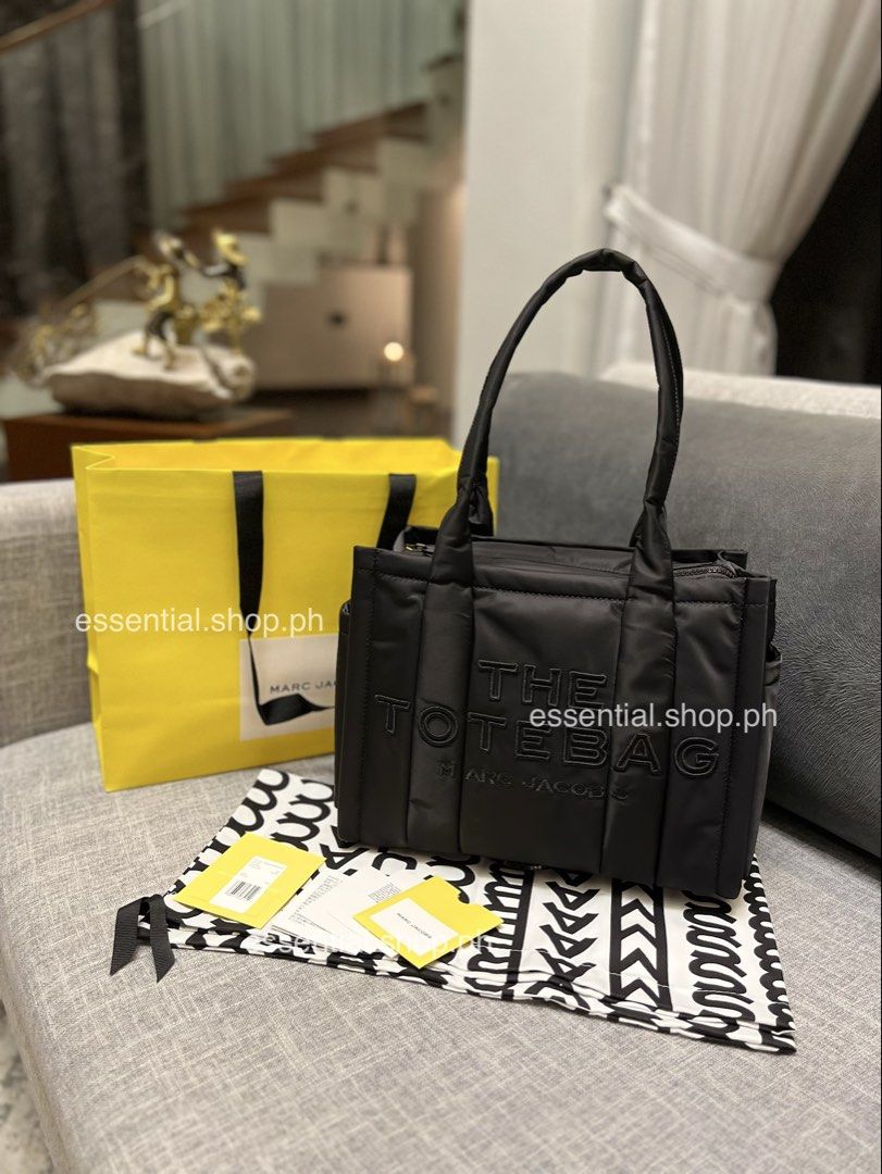Authentic Marc Jacobs Medium Puffer Tote Black (Category: Tote Bags) located in Manila. Submitted by essential.shop.ph (Listing ID 1469931233, Image 1). Description: FOR PRE-ORDER. 7-10 days ETA ☺️ Authentic Marc Jacobs Nylon Medium Puffer Tote Cement color Top zip closure Top handle 2 external side pockets 1 Interior Slip Pocket, 1 Interior Zip Pocket Polyester Lining Includes paper bag, dust bag, tag and care cards. Dimensions L 33cm x D 15cm D