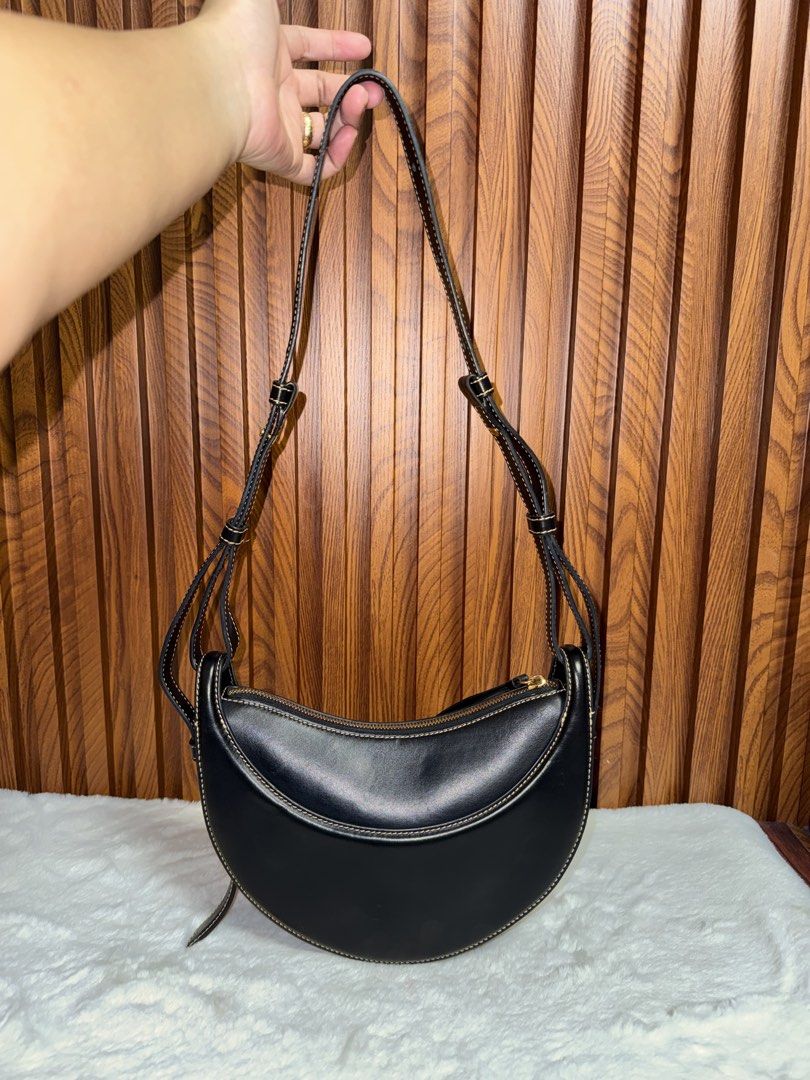 Authentic Polène Black Leather Shoulder Bag (Category: Everything Else Others) located in Subic. Submitted by luxshoppe88 (Listing ID 1469857473, Image 3). Description: Polène black leather shoulder bag with contrast stitching. Curved crescent shape with gold-tone hardware and top zip closure. Adjustable strap with multiple settings. Interior has a clean fabric lining with a slip pocket. Minimalist design goes with everything. Shows minor wear on