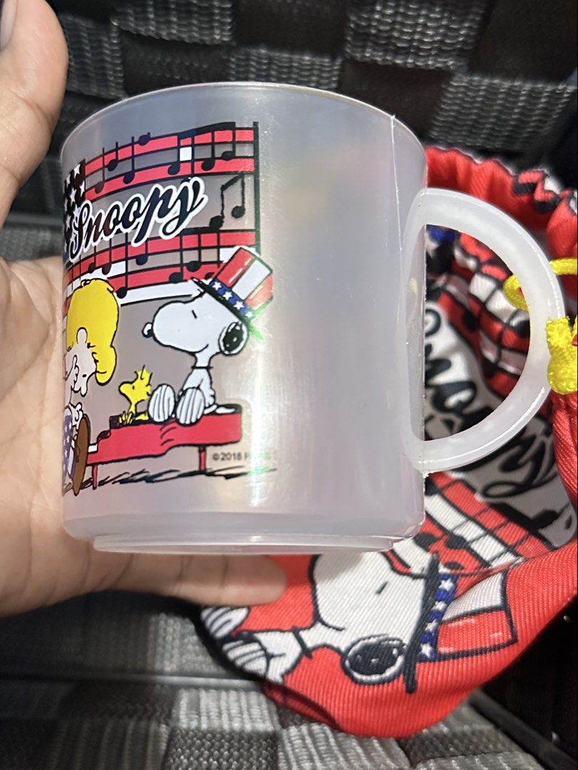 Authentic Snoopy lightweight plastic mug with pouch (Category: Water Bottles & Tumblers) located in General Santos City (Dadiangas). Submitted by toysville888 (Listing ID 1469869849, Image 1). Description: BRAND NEW Authentic Snoopy lightweight plastic mug • Material: Lightweight, break-resistant frosted/clear plastic. • Design: Snoopy in a patriotic top hat alongside Woodstock and musical staff graphics, dated © 2018. • Accessory: Paired with a 