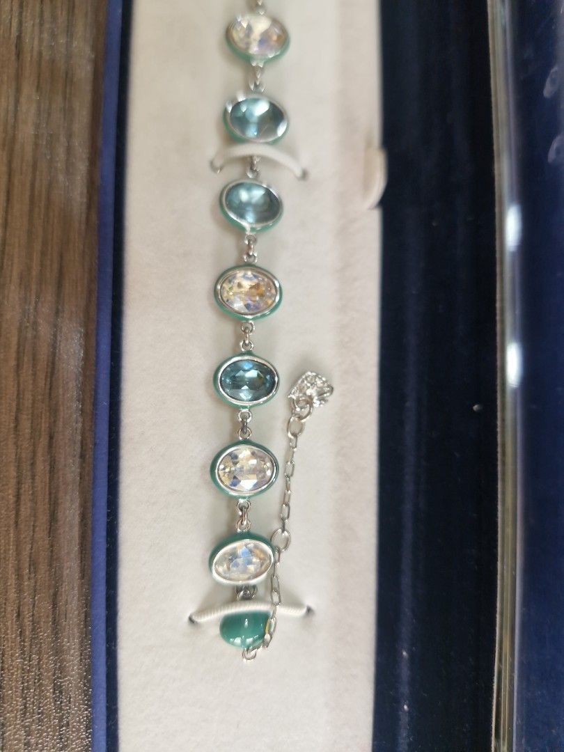 AUTHENTIC SWAROVSKI CRYSTAL BRACELET (Category: Bracelets) located in Quezon City. Submitted by thercor (Listing ID 1469770437, Image 3). Description: - one of a kind - used once only - Faceted oval crystals in yellow, clear, and greenish-blue with smooth green bead accents - Metal: Silver-tone with secure lobster clasp closure - Condition: Excellent sparkle, well-maintained - Comes with original dark blue box rfs decluttering, gifted around earl