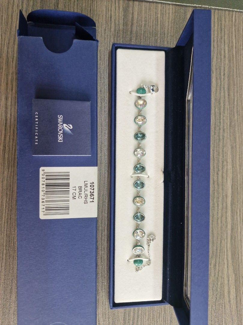 AUTHENTIC SWAROVSKI CRYSTAL BRACELET (Category: Bracelets) located in Quezon City. Submitted by thercor (Listing ID 1469770437, Image 1). Description: - one of a kind - used once only - Faceted oval crystals in yellow, clear, and greenish-blue with smooth green bead accents - Metal: Silver-tone with secure lobster clasp closure - Condition: Excellent sparkle, well-maintained - Comes with original dark blue box rfs decluttering, gifted around earl
