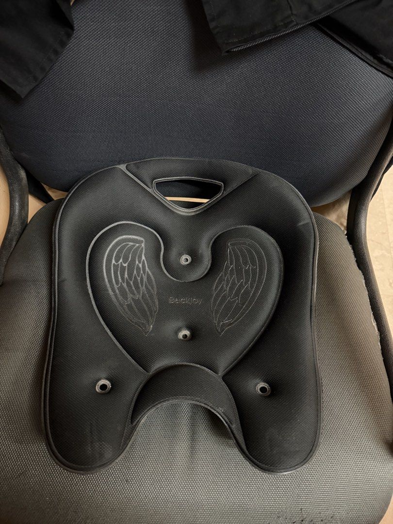 BackJoy SitSmart Angel Traction Black Posture Seat (Category: Braces, Support & Protection) located in Caloocan City. Submitted by bbkk08 (Listing ID 1469784202, Image 1). Description: Black BackJoy SitSmart Angel Traction posture seat. Ergonomic design with angel wing graphics on the seating surface. Built-in handle at the top for easy carrying. Certilogo authenticity sticker attached on the bottom shell. Helps correct sitting posture during lon