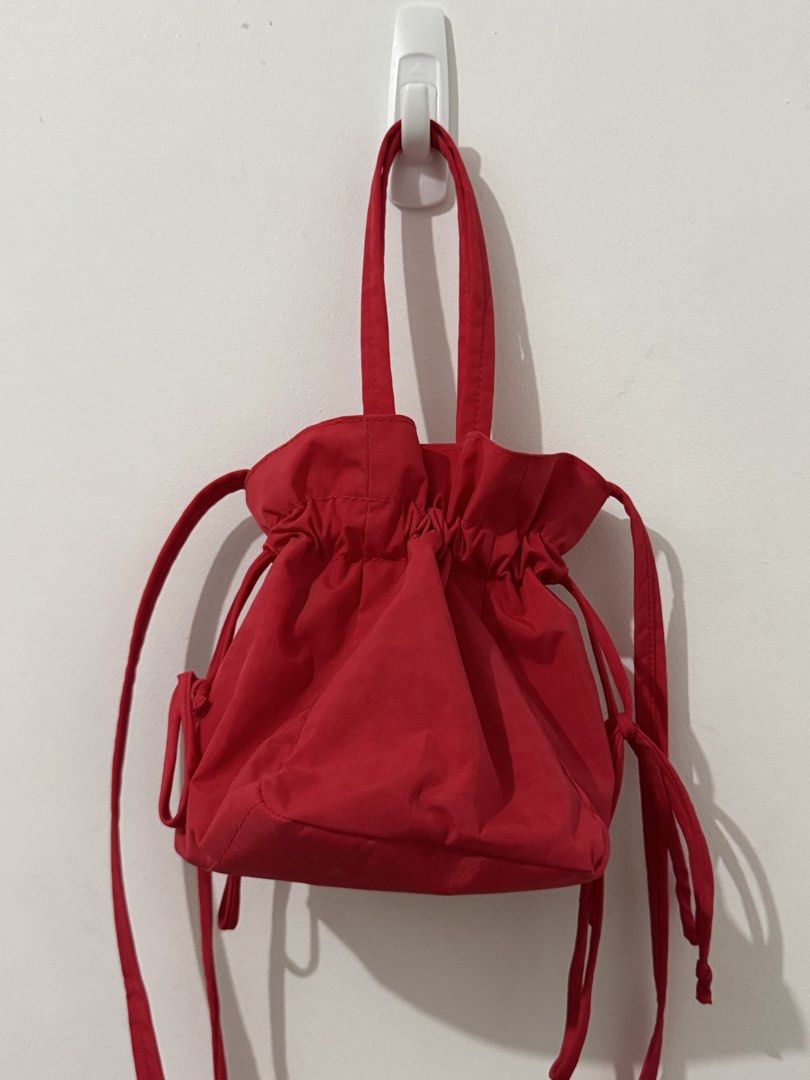 BAGGU Drawstring Bag - Candy Apple Red (Category: Tote Bags) located in Quezon City. Submitted by afpar (Listing ID 1469829828, Image 1). Description: - Brand: Baggu - Color: Bright red - Material: Durable nylon - Features: Top handles, adjustable crossbody strap, and secure drawstring closure - Interior: Includes a handy zippered pocket for small essentials - Condition: Vibrant color with minimal signs of wear.