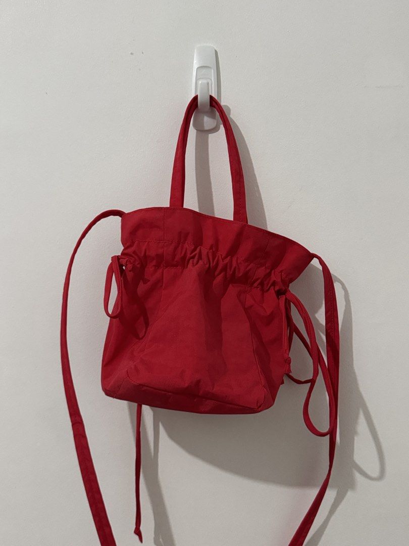 BAGGU Drawstring Bag - Candy Apple Red (Category: Tote Bags) located in Quezon City. Submitted by afpar (Listing ID 1469829828, Image 2). Description: - Brand: Baggu - Color: Bright red - Material: Durable nylon - Features: Top handles, adjustable crossbody strap, and secure drawstring closure - Interior: Includes a handy zippered pocket for small essentials - Condition: Vibrant color with minimal signs of wear.