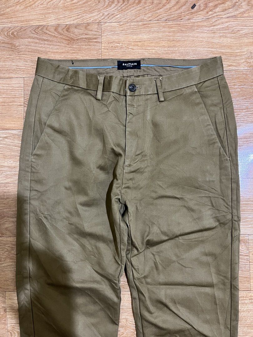 Bal (Category: Luxury Apparel) located in Zamboanga. Submitted by alterramz08 (Listing ID 1469925450, Image 3). Description: Balmain chino pants Size 30 length 35 Thigh 11 Leg Opening 7 Verygood Condition Issue altered length Price : 1,000 Pesos !! The image shows a pair of olive or sage-green cotton trousers/chinos bearing a Balmain waistband label, resembling Balmain’s straight-leg cut chino or cotton twill trousers..