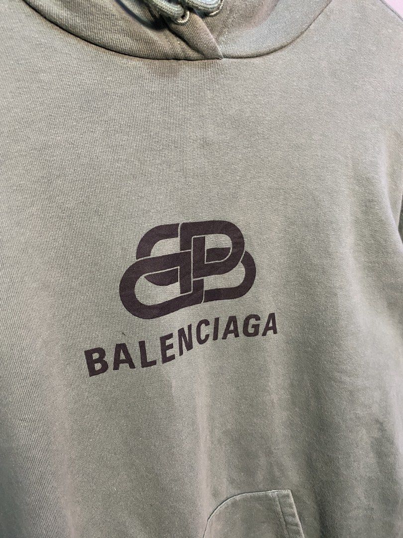 Balenciaga BB Mode Green Hoodie (Category: Hoodies) located in Caloocan City. Submitted by retrowear.gallery (Listing ID 1469777345, Image 2). Description: - Brand: Balenciaga - Color: Muted sage green - Design: Large BB logo graphic printed on the chest - Features: Drawstring hood, front kangaroo pocket, ribbed cuffs and hem - Origin: Made in Portugal - Condition/Details: Collar tag and interior wash labels attached - Perfect for elevated street