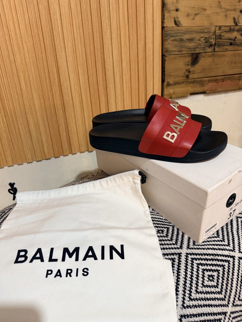 Balmain Paris Red Slides Sandals Size 37 with Box (Category: Flats & Sandals) located in Makati City. Submitted by ziagabrielle (Listing ID 1469765205, Image 1). Description: Balmain Paris slides in red and black. Gold tone logo lettering across the wide strap. Size 37. Includes original white dust bag and branded shoebox. Slip-on design with textured footbed. Grab these statement designer sandals for your footwear rotation. dustbag, box and pape
