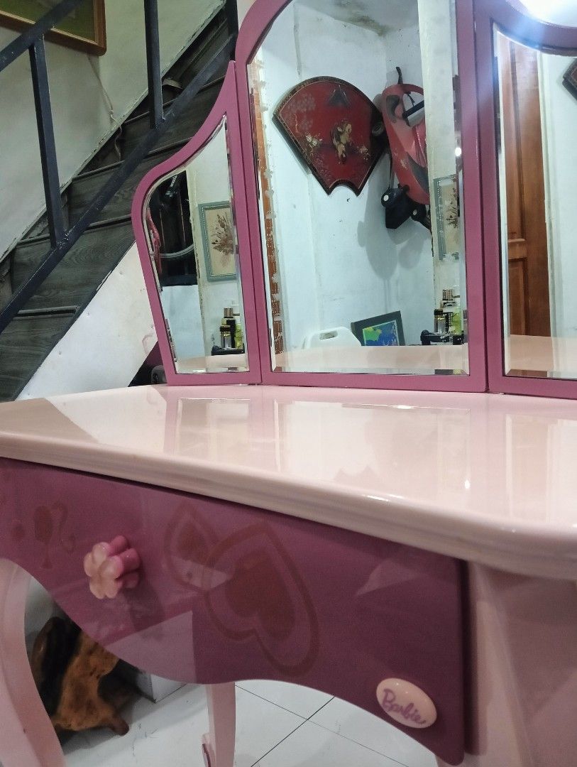 Barbie Kids Vanity Table with Tri-Fold Mirror (Category: Kids Toys) located in Manila. Submitted by josewendel71226 (Listing ID 1469890182, Image 2). Description: - Pink Barbie vanity table with tri-fold mirror - Features 1 pull-out drawer with a flower-shaped knob and elegant curved legs - Made of sturdy wood with a glossy finish - Includes original product safety and warranty sticker on the back - Condition: Noticeable peeling and chipping on t