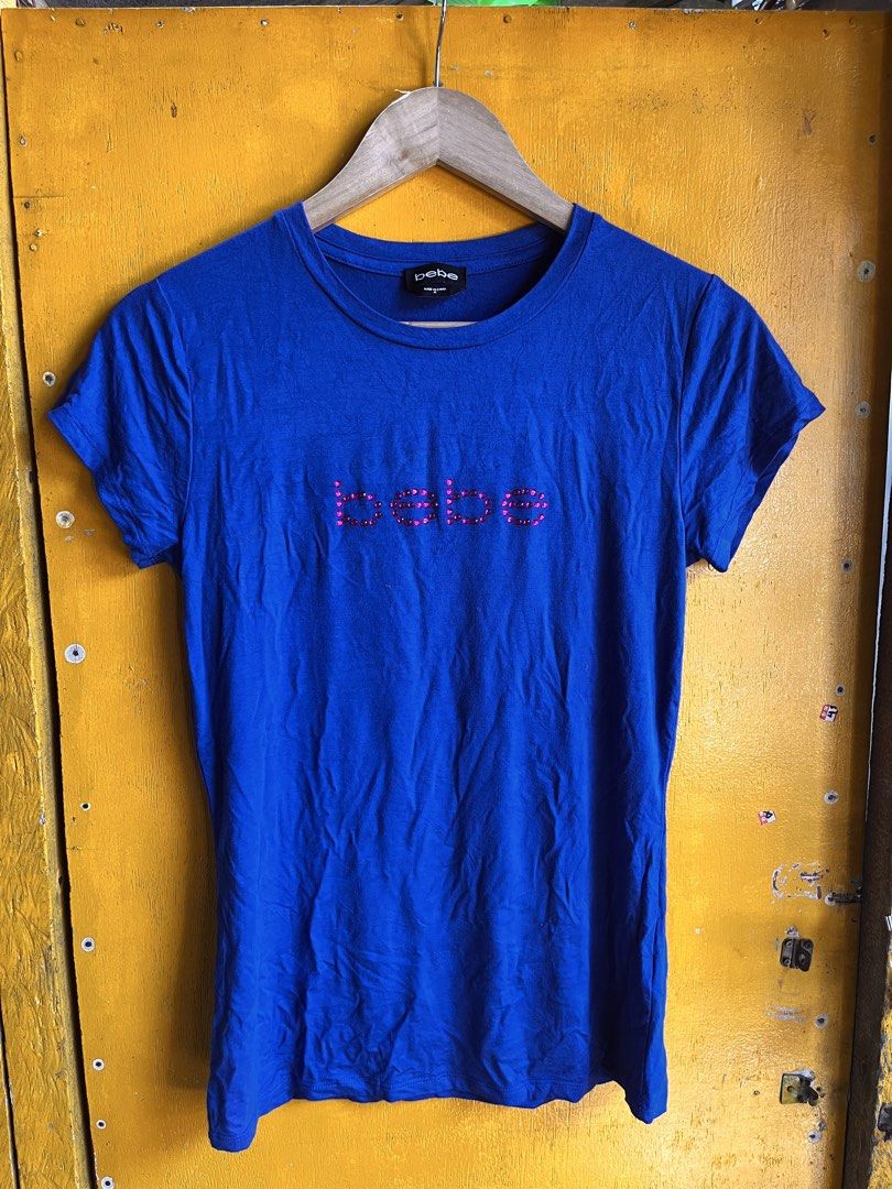 bebe Blue T-shirt with Rhinestone Logo (Category: Shirts) located in Manila. Submitted by seth_inting. (Listing ID 1469910227, Image 1). Description: - Brand: bebe - Color: Bright blue - Size: M - Material: Soft cotton blend - Details: Pink rhinestone logo embellishment on chest, crew neck, standard fit - Condition: Great for casual everyday wear - Origin: Made in China.