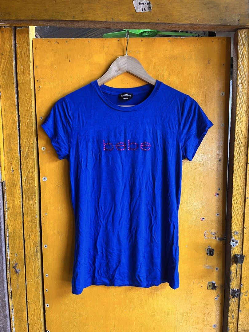 bebe Blue T-shirt with Rhinestone Logo (Category: Shirts) located in Manila. Submitted by seth_inting. (Listing ID 1469910227, Image 2). Description: - Brand: bebe - Color: Bright blue - Size: M - Material: Soft cotton blend - Details: Pink rhinestone logo embellishment on chest, crew neck, standard fit - Condition: Great for casual everyday wear - Origin: Made in China.